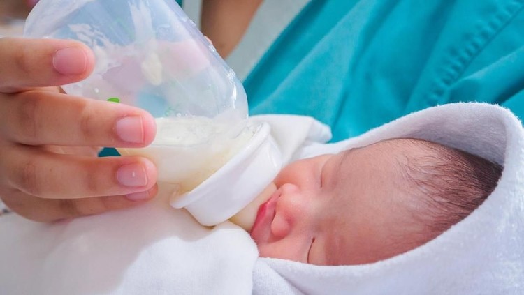 susu bayi Mother feeding newborn baby from the bottle