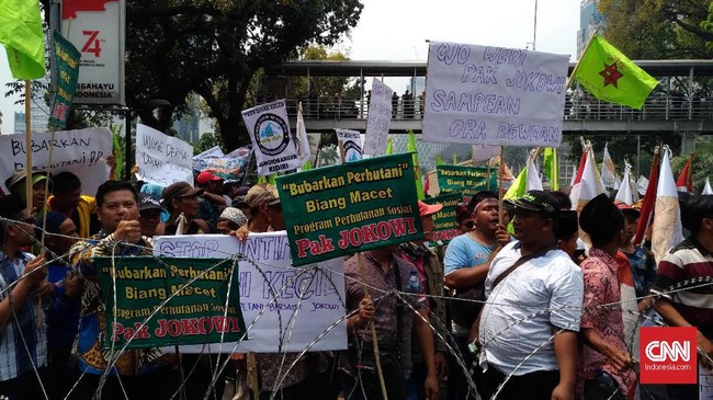 Para petani mengancam akan menginap di sekitar Patung Kuda, Jakarta, karena diadang kepolisian saat menuju ke Istana Kepresidenan Jokowi.