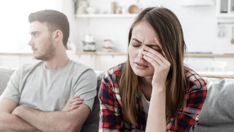 zodiak Couple conflict. Stressed crying female sitting on couch with abusive husband after quarrel, ready to divorce