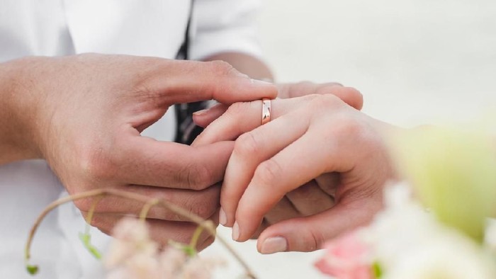 Groom wears the ring on the finger of the bride
