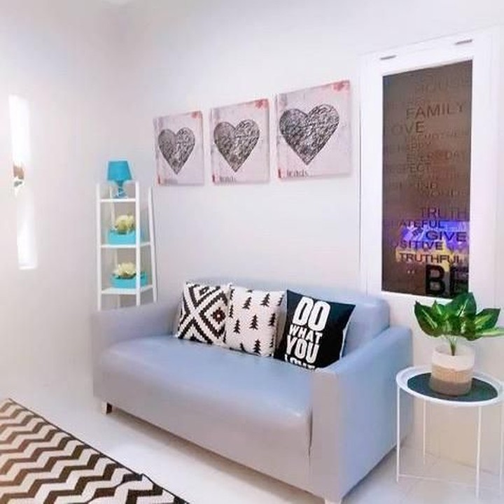 <p>Masuk ke dalam rumah, ruang tamu terlihat jadi lebih lebar. Kuncinya dengan memilih cat tembok warna putih, dikombinasikan dengan sofa berwarna lembut. Permainan warna monokrom membuat ruang terbatas terasa luas. (Foto: Instagram @shusihome)</p>