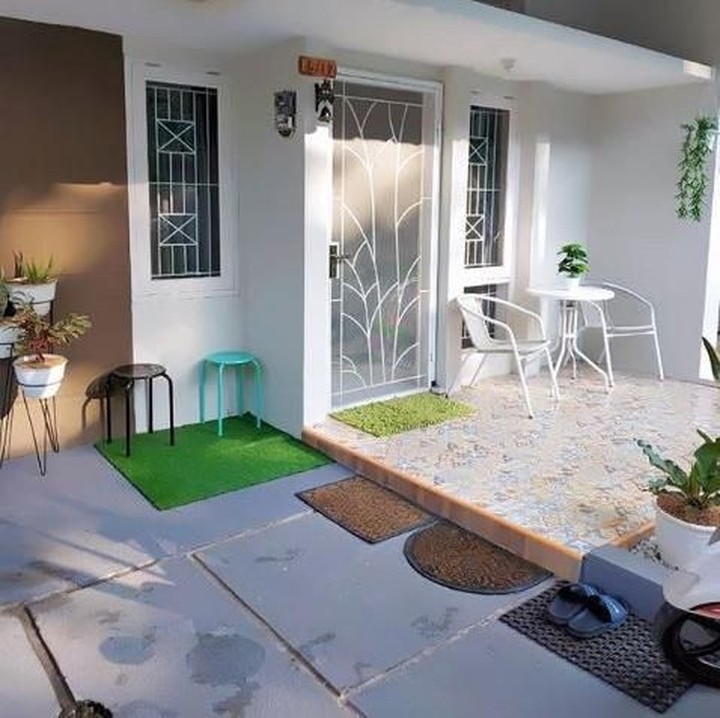 <p>Sudut teras depan dimanfaatkan dengan baik oleh pemilik rumah. Ia meletakkan rumput sintetis dan bangku-bangku kecil untuk memberi aksen lebih segar dan natural. (Foto: Instagram @shusihome)</p>