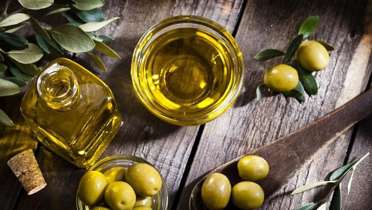 Olives assortment in bowl with oil. Top view. Copy space