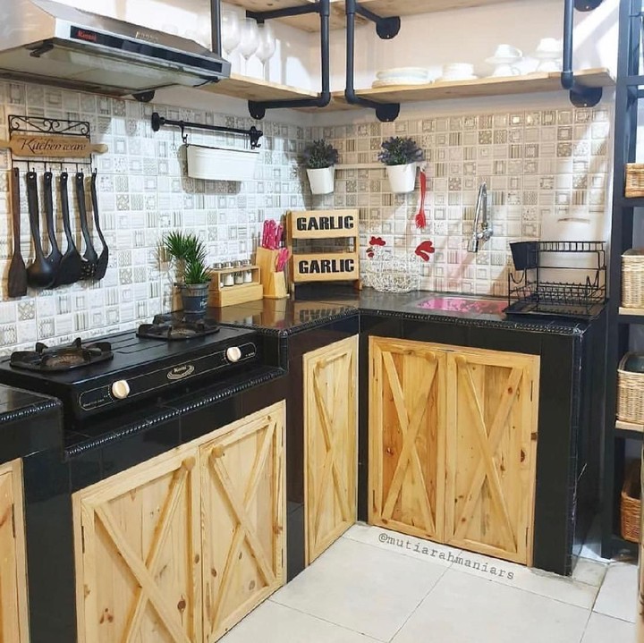 <p>Dapur dengan warna cokelat dan hitam ini terlihat keren dan tidak terlalu feminin. Pemilik juga menggunakan rak gantung bersusun untuk menyimpan dekorasi. (Foto: Instagram @dekorasidapur)</p>