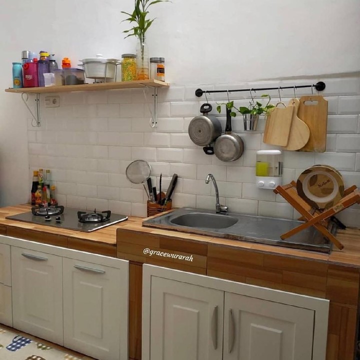 <p>Hampir sama seperti dapur tadi, dapur ini juga berwarna putih dan cokelat. Penggunaan rak gantung seperti ini juga bisa mengakali agar ruangan yang sempit tetap terlihat rapi. (Foto: Instagram @gracewurarah)</p>