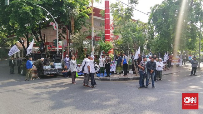 Dengan hanya berjarak sekitar 100 meter, massa pendukung Gus Nur dan Banser berhadapan di depan Gedung PN Surabaya. Polisi berjaga ketat.
