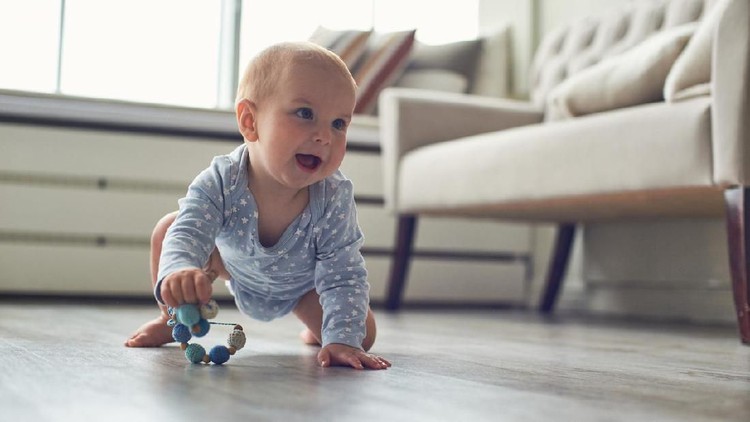 little baby boy crawling on floor at home.