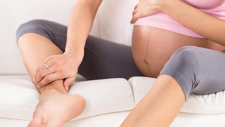 Kaki bengkak Pregnant woman with swollen feet and leg pain.
