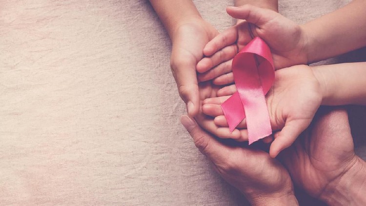 Family hands holding pink ribbon, breast cancer awareness, October pink concept