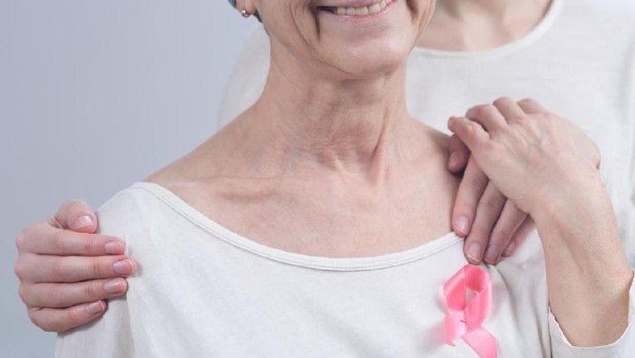 Cropped picture of a sick woman wearing a pink ribbon