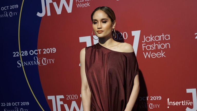 Cinta Laura hadir sebagai tamu undagan di Jakarta Fashion Week 2020. Ia tampil mempesona dengan busana berwarna merah maroon.