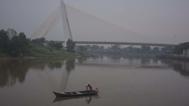 Kabut asap tipis menyelimuti Kota Pekanbaru, Riau, Minggu (28/7/2019). Berdasarkan data Satgas Karhutla Riau, kualitas udara di sejumlah area di Pekanbaru, Kampar, Rohil, Bengkalis dan Siak mulai menurun ke kondisi sedang hingga tidak sehat akibat pengaruh asap kebakaran hutan dan lahan (Karhutla) yang belum bisa dipadamkan total. ANTARA FOTO/FB Anggoro/aww.