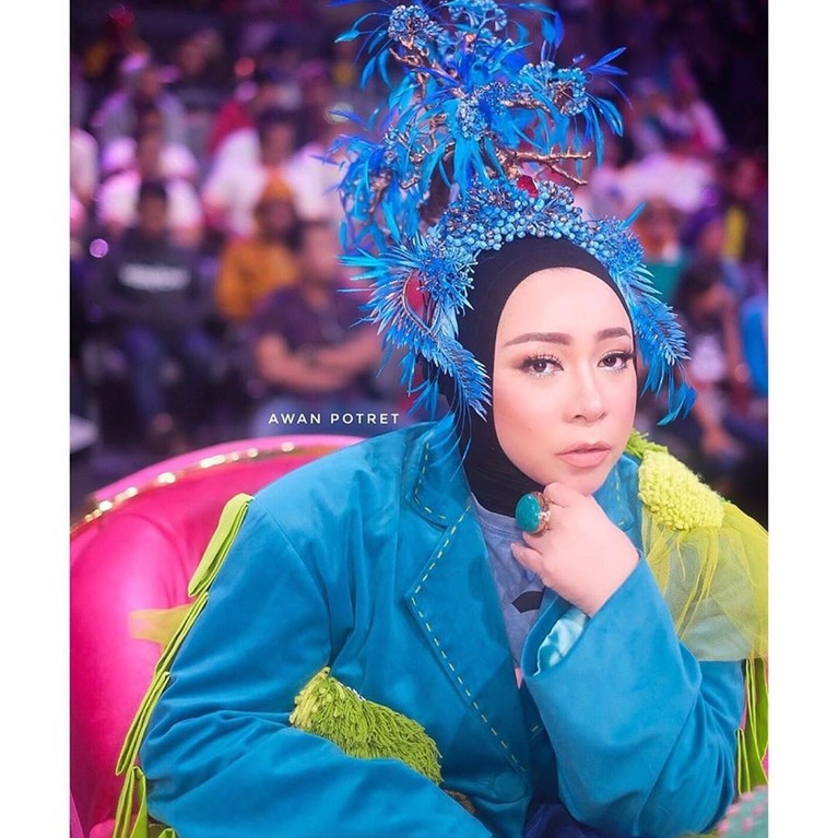 Melly Goeslaw beberapa waktu belakangan nampak tampil berbeda dengan gaya busana dan headpiece yang unik dan nyentrik. Seperti apa penampilannya?