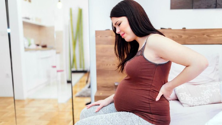 Pregnant woman having back aches  in the last trimester of pregnancy