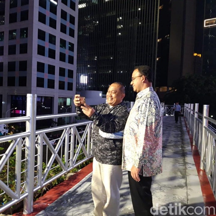 Gubernur DKI Jakarta, Anies Baswedan tampak berswafoto dengan pejalan kaki di JPO. (Foto: Anies di JPO tanpa atap (Rahel/detikcom))