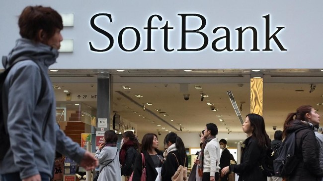 This picture taken on November 23, 2018 shows people walking in front of a shop of Japan's telecoms giant SoftBank in Tokyo. (Photo by Kazuhiro NOGI / AFP)