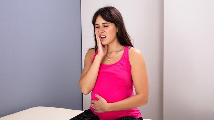 Young Pregnant Woman With Painful Expression Suffering From Toothache In Clinic