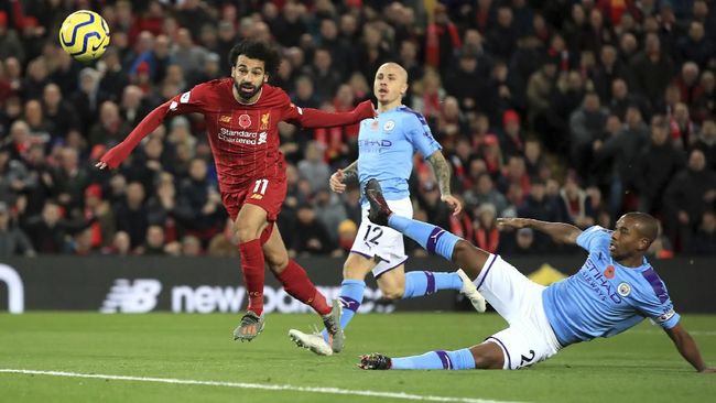 Liverpool's Mohamed Salah, left, scores his side's second goal of the game during the English Premier League soccer  match at Anfield, Liverpool, England, Sunday Nov. 10, 2019. (Peter Byrne/PA via AP)