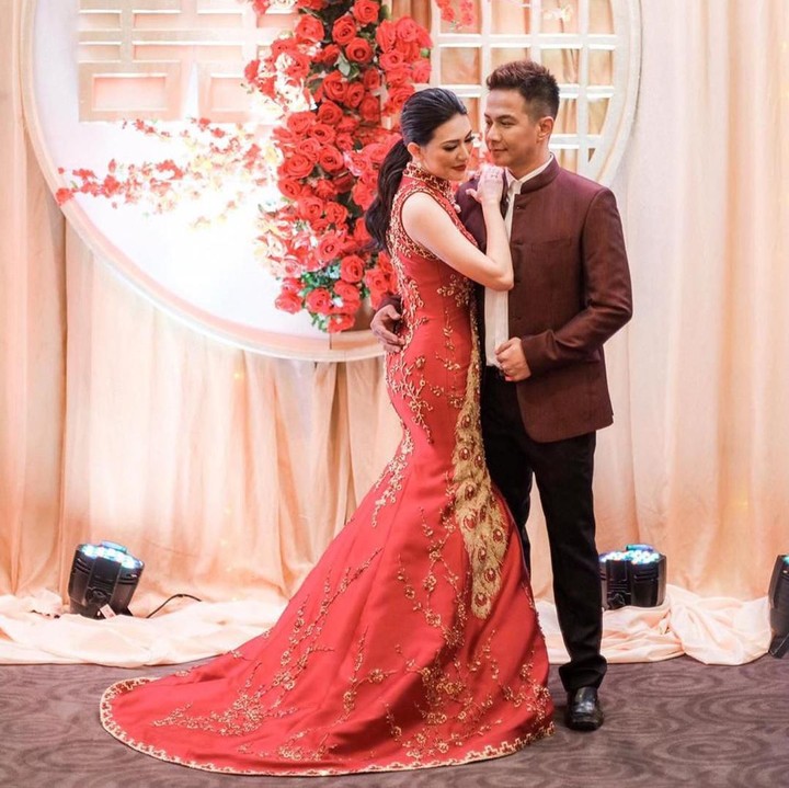 Aida tampak anggun mengenakan gaun berwarna merah, serasi dengan Delon yang mengenakan jas merah tua. (Foto: Instagram @cynthiatan__)