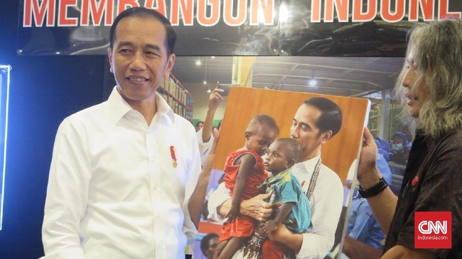 Dalam pameran foto Membangun Indonesia, Presiden Jokowi mengaku sangat terkesan dengan hasil bidikan fotografer, saat dirinya sedang menggendong dua anak Papua.