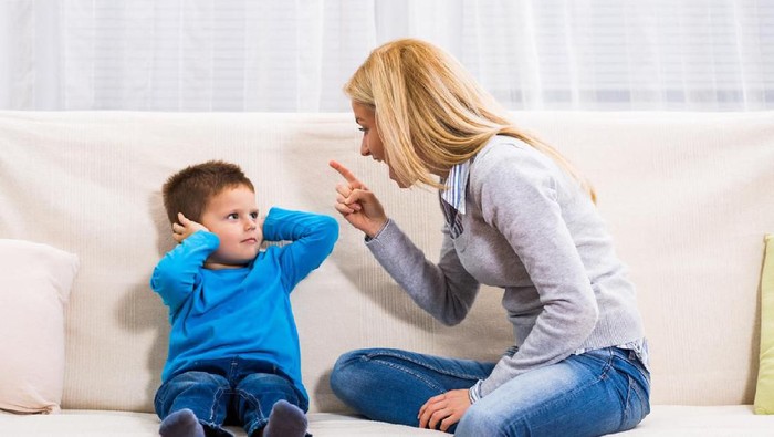 Angry mother is scolding at her son.