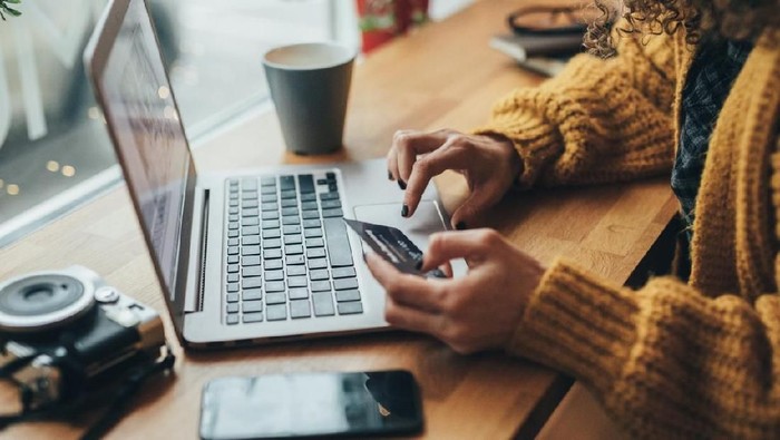 Woman in cafe shopping online with laptop