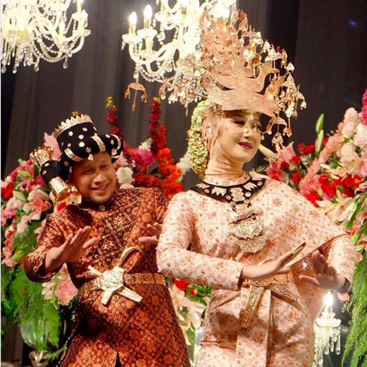 <p>Dian terlihat mengenakan songket berwarna lembut. Meski mengenakan siger, tapi busana pengantinnya terlihat sudah dimodifikasi dan dilengkapi dengan <em>mini cape</em> pengganti selendang. Sedangkan sang suami terlihat gagah dengan songket berwarna merah marun kombinasi keemasan. Benar-benar serasi ya, Bun? (Foto: Instagram @sistawedding)</p>