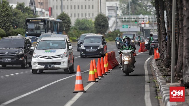 Sejumlah pengendara sepeda motor melewati jalur sepeda di Jalan M.H. Thamrin, Jakarta, Jumat, 22 November 2019. Polda Metro Jaya bekerjasama dengan Dishub DKI Jakarta mulai menerapkan aturan jalur sepeda pada Jumat ini dengan memberikan sanksi denda tilang maksimum Rp 500.000,- hingga penderekan bagi kendaraan bermotor yang melanggar jalur sepeda. CNN Indonesia/Bisma Septalisma