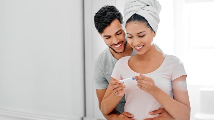 Shot of a happy young couple looking at their pregnancy test results in the bathroom at home