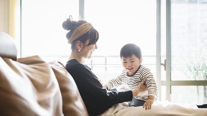 Asian mother and baby communicating in the living room.