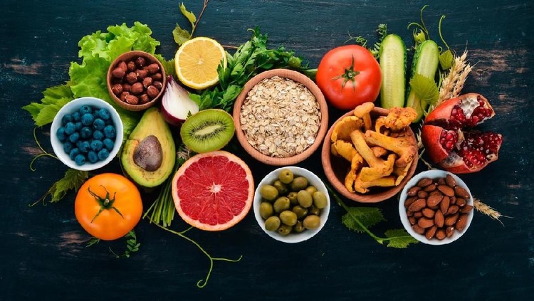 Healthy food clean eating selection: Vegetables, fruits, nuts, berries and mushrooms, parsley, spices. On a black background. Free space for text.