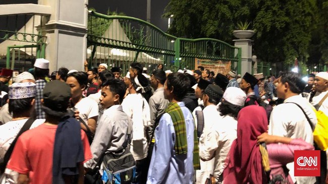 Ratusan massa Reuni 212 mulai berdatangan ke Monas, namun tertahan tak bisa masuk ke dalam karena pintu gerbang ditutup sejak sore oleh aparat yang berjaga.