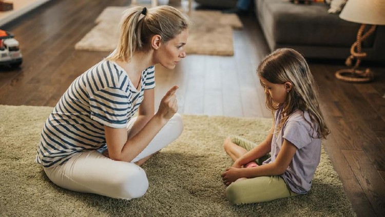 Young mother scolding her sad little daughter who made a mistake.