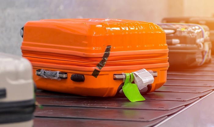 Suitcase or luggage with conveyor belt in the airport. Alasan Jangan Tandai Koper dengan Pita Berwarna Cerah