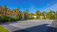 Ada juga lapangan basket yang dikelilingi pepohonan. (Foto: Homes and Property)
