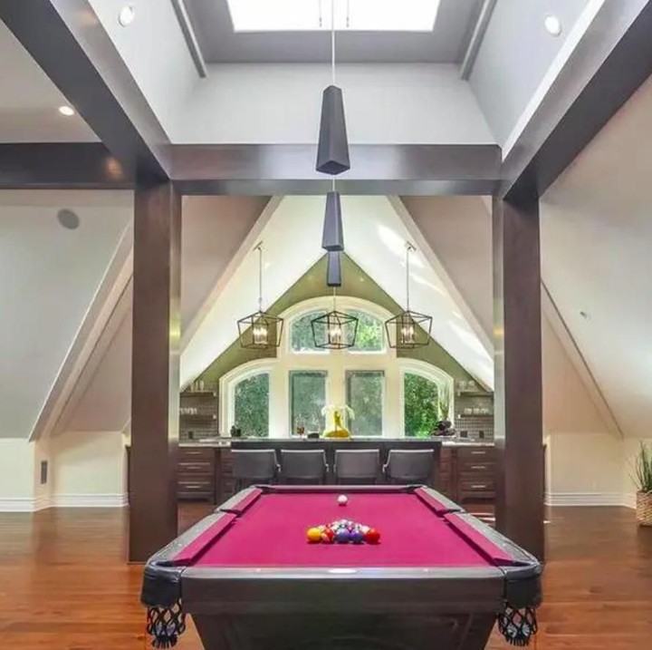Meja biliar yang mewah terletak tak jauh dari ruang bersantai. Berbeda dengan kebanyaka meja biliar, kali ini dipenuhi dengan sentuhan fuchia yang elegan. (Foto: Homes and Property)