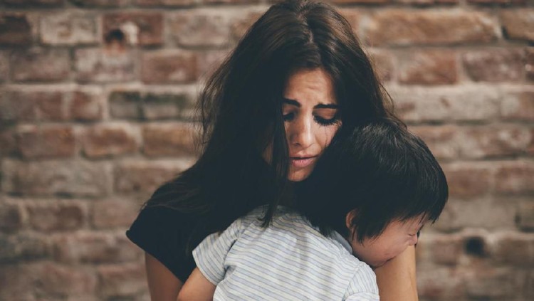 Mother holding little boy and crying, family violence