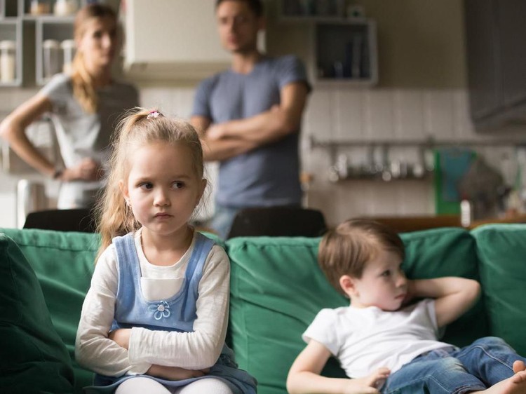 Frustrated kid girl feels upset, offended or bored ignoring avoiding worried parents and brother, little sad sister not talking to child boy after fight sulking sitting on couch, siblings rivalry