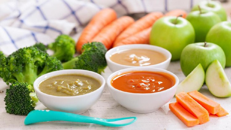 Baby food. Various bowls of fruit and vegetable puree with ingredients for cooking on wooden table