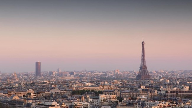 Paris, France - April 11, 2019: View of the city and Eiffel Tower on a clear sky sunset into dusk.