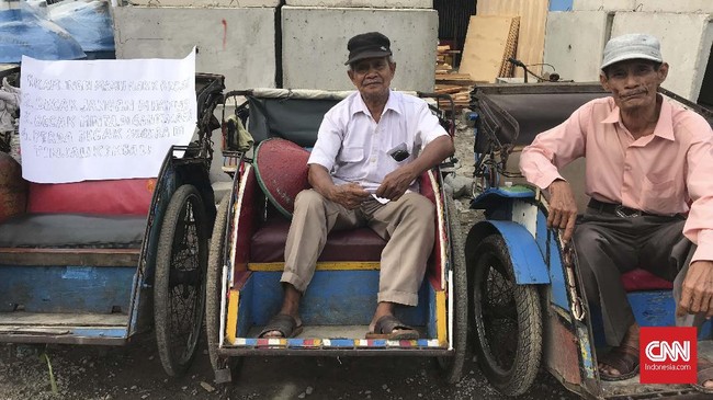 Lewat pesan yang dituliskan di sebuah kertas karton putih besar, penarik becak di Jakarta Utara berharap Gubernur Anies terketuk hatinya melihat nasib mereka.