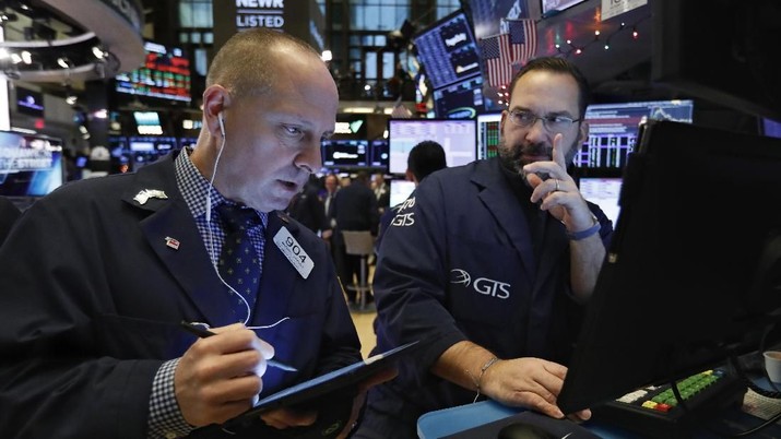 Trader Gregory Rowe, right, works on the floor of the New York Stock Exchange, Wednesday, Dec. 11, 2019. Stocks are opening mixed on Wall Street following news reports that US President Donald Trump might delay a tariff hike on Chinese goods set to go into effect this weekend. (AP Photo/Richard Drew)