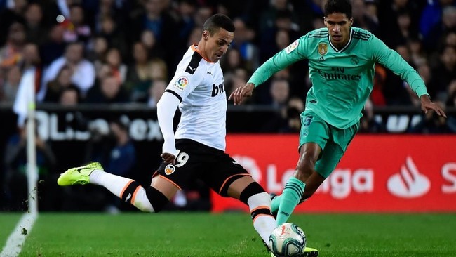Real Madrid's French defender Raphael Varane (R) vies with Valencia's Spanish forward Rodrigo Moreno during the Spanish League football match between Valencia CF and Real Madrid, at the Mestalla stadium in Valencia, on December 15, 2019. (Photo by JOSE JORDAN / AFP)