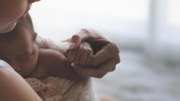 Close up Mother holding hands Asian female newborn baby  and sunlight in the morning. Cute little girl  three weeks old. Health, care, love, relationship concept.