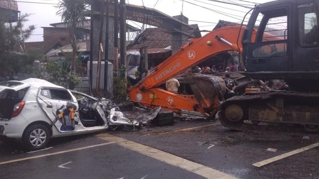Truk pembawa alat berat diduga mengalami rem blong sehingga menabrak sejumlah kendaraan di depannya sehingga menewaskan tujuh orang.