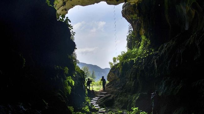 Visitors stand in front of a cave in Lhoong, Aceh province on December 22, 2019. - The cave is believed to be about 7,400 years old and holds deposits of previous tsunamis.The cave is believed to be about 7,400 years old and holds deposits of previous tsunamis. (Photo by CHAIDEER MAHYUDDIN / AFP)