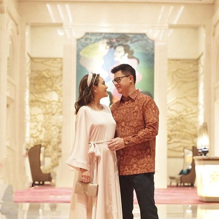Shandy Aulia nampak cantik mengenakan asimetris dress berwarna clean. Busana polos tanpa motif membuat penampilannya clean. Cocok dengan suami, David Herbowo yang berbatik coklat. (Foto: Instagram @shandyaulia)