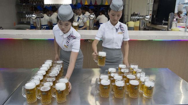This photo taken on August 12, 2016 shows waitresses preparing jugs of beer before the opening of the Pyongyang Taedonggang Beer Festival on the banks of the Taedong river in Pyongyang. (Photo by Kim Won-Jin / AFP)