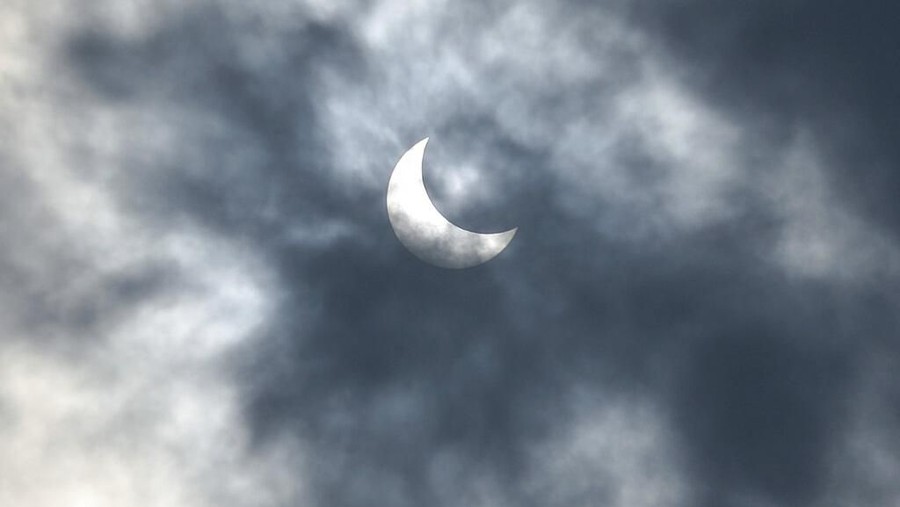 People look up at the sun with protective glasses to watch a solar eclipse from Jakarta, Indonesia, Thursday, Dec. 26, 2019. (AP Photo/Tatan Syuflana)