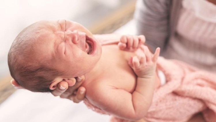1034319328 Selected focus on little cute baby crying on her mother hand.